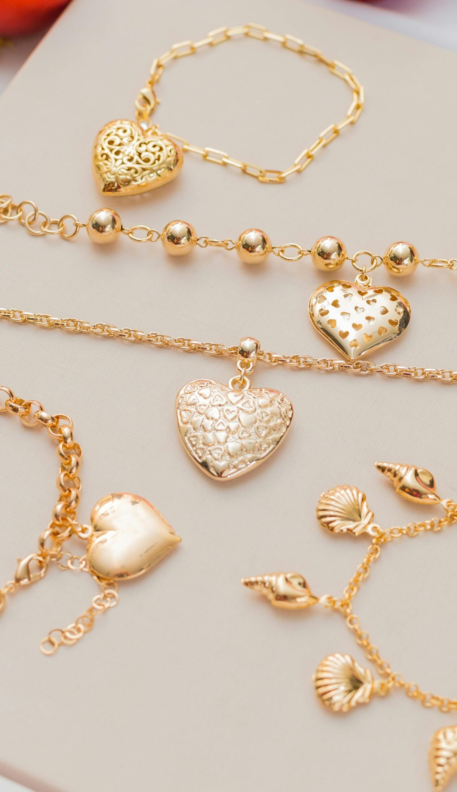 Elegant gold bracelets and necklaces with heart pendants, ideal for fashion or Valentine's Day themes.